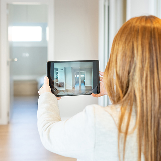 A woman is taking a video of a flat on her tablet